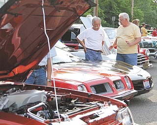 Joe Carbon of Poland, left, talks about his 2002 Corvette with Mike Yajich during Cruisin’ the River, which is sponsored by the Lowellville Business Association. The event takes place from 6 to 9 p.m. Mondays, or 5 to 8 p.m. Mondays on and after Labor Day.