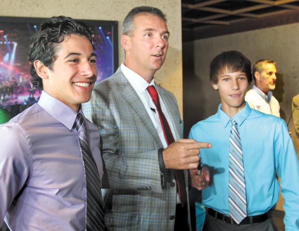 Ohio State football coach Urban Meyer talks with Andrew Wollet, 17, left and his brother Alex Wollet, 14, both of Poland, during the United Way’s “Champions Among Us” dinner Monday at the Covelli Centre in Youngstown. Meyer was the keynote speaker at the event, which is the agency’s biggest fundraiser.