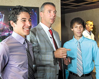 Ohio State football coach Urban Meyer talks with Andrew Wollet, 17, left and his brother Alex Wollet, 14, both of Poland, during the United Way’s “Champions Among Us” dinner Monday at the Covelli Centre in Youngstown. Meyer was the keynote speaker at the event, which is the agency’s biggest fundraiser.