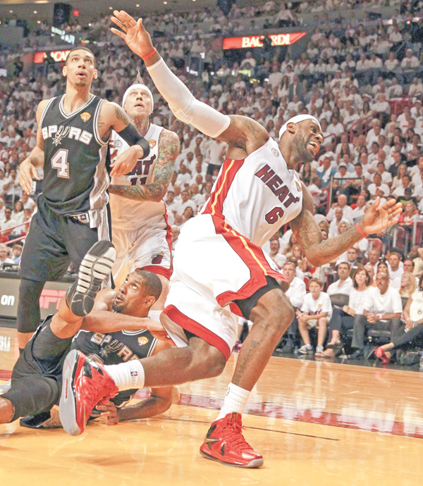The Heat’s LeBron James collides with the Spurs’ Tim Duncan under the basket during the second quarter
in Game 6 of the NBA Finals on Tuesday at American-Airlines Arena in Miami. The Heat rallied to force the
game into overtime, then edged the Spurs, 103-100, to even the series 3-3. Game 7 is set for 9 p.m. Thursday in
Miami.