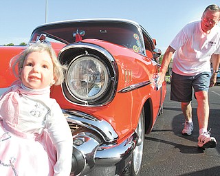 Jerry Apger of Lordstown shines his 1957 Chevrolet while “Barbie,” a doll that rides in the back seat of his classic car, sits on the front bumper during the Senior Center Car Cruise in Austintown.