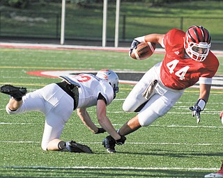 Mahoning’s David Stewart (44) of Struthers is tripped up by Trumbull’s Brandon Harb (12) of Hubbard during the first half of the 29th Jack Arvin Football Classic on Thursday at Girard’s Arrowhead Stadium. Mahoning defeated Trumbull, 34-26.