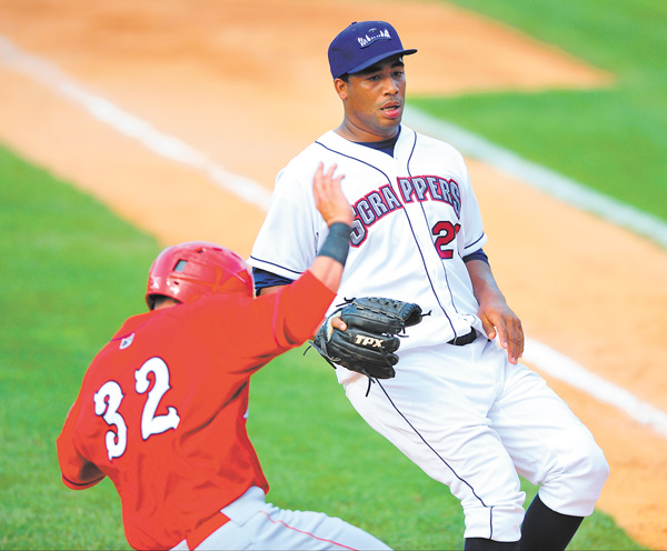 Auburn baserunner Erick Fernandez slides into home plate while Scrappers pitcher Harold Guerrero attempts
to cover home after throwing a wild pitch in the top of the sixth inning of Sunday’s New York-Penn League game at Eastwood Field. The Scrappers won 3-1.