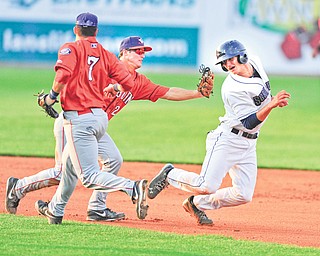 Scrappers baserunner Martin Cervenka, right, tries to avoid the tag of Doubledays infielder Cody Dent after being caught in a rundown in the fourth inning of Monday’s game. Cervenka was eventually tagged out.