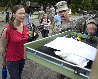 Kelli Cardinal/The Vindicator
Sgt. Robert Griffin, from Wooster, explains the uses for a contact truck Sunday to Rebecca Helderman at the Ohio Army National Guard B Co., 237th Brigade Support Battalion open house at Christy Armory in Austintown.  A contact truck is used as a mobil maintenance truck for other military vehicles.