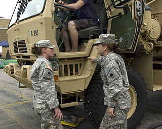 Kelli Cardinal/The Vindicator
Army Specialists Lindsay Davis, left, from Broadview Heights, and Kayla Kimball, from Toronto, Ohio, talk Sunday with Kimball's fiance, Ronald Holmes, from Toronto, while he sits in M1087 Expandable Van during the Ohio Army National Guard B Co., 237th Brigade Support Battalion open house at Christy Armory in Austintown. The van is used as a mobile office in the field.