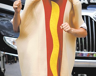 Chris Petri dances in his hot dog costume during Harry Stevens Hot Dog Day. The event included a parade, music
and wiener-dog races.