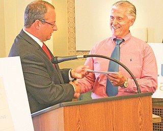 Steve Buehrer, the Ohio Bureau of Workers’ Compensation’s administrator and chief executive officer, hands over a $590,517 check to Youngstown Mayor Charles Sammarone.