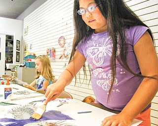 Zoe Schlosser, 10, paints at the Trumbull Art galley in Warren as she learns about artist Kenneth Patchen, whose work is on display. Summerfest for children had the kids create art inspired by him.