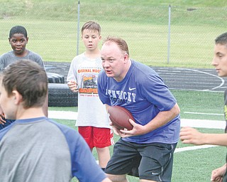 University of Kentucky football coach and Cardinal Mooney graduate Mark Stoops conducts drills during the Camp of Champions on Monday at Cardinal Mooney High School. Area youths in grades four through nine participated in the annual event, which concludes today.
