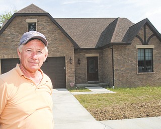 Ken Zuzik, who has been building homes in the Mahoning Valley since 1987, stands near one of the completed units in the Abbey Road Villas development in Canfield.