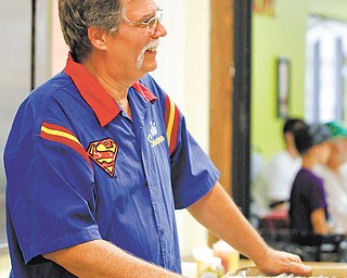 Ed Szabo of Hermitage, Pa., dressed in a Superman smock, sells comic books at the 2013 Annual Americon show. Hundreds of people bought merchandise that included Marvel, DC and other vintage comic books, as well as video games, small action figures and more.