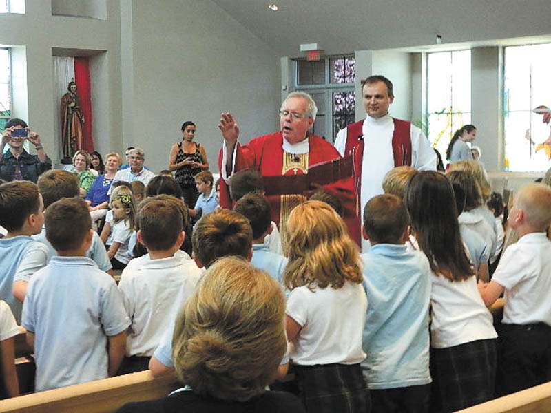 SPECIAL TO THE VINDICATOR
Monsignor William Connell and the Rev. Martin Celuch blessed the students of Holy Family School in Poland on the last day of classes, June 5. Tradition continued as the students in kindergarten through seventh grade received a blessing with holy water and then were commissioned to the next grade level.