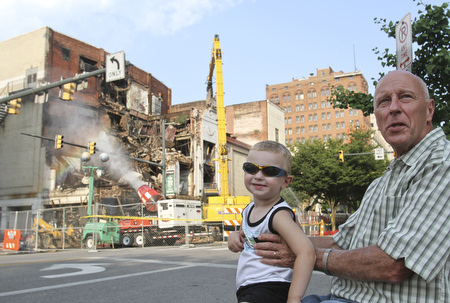 William D. Lewis\The Vindicator.Loren Kindler and his grandson Clark McAllen, 2, watch demolition of the Paramount Theater in downtown Youngstown 7-9-13. Kindler's father worked in the building.