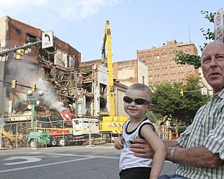 William D. Lewis\The Vindicator.Loren Kindler and his grandson Clark McAllen, 2, watch demolition of the Paramount Theater in downtown Youngstown 7-9-13. Kindler's father worked in the building.