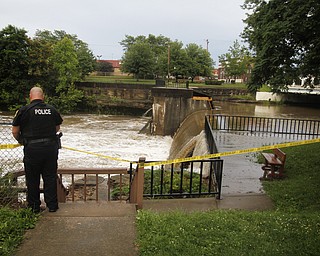 MADELYN P. HASTINGS I THE VINDICATOR
Newton Falls Police Officer Mark Brown taped off a section of the dam near Veteran's Park in Newton Falls over the west branch of the Mahoning River after a storm caused major flooding on July 10, 2013.