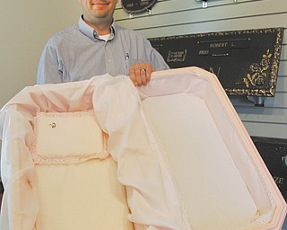 Jason Bonomo, Ohio regional sales manager for Bronze Stone Group, which includes Pet Haven Memorial Gardens in Canfield, said the pet cemetery offers basic pet shells and fancy ones, such as the one he is holding.