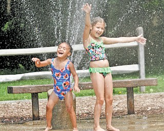 Aaliyah Massrock, 3, left, and Tatum Thomas, 8 enjoy the cool, refreshing spray from a sprinkler at the Walter Scholl Recreation Area in Mill Creek Park. Temperatures reached 89 degrees in the Valley on Tuesday.