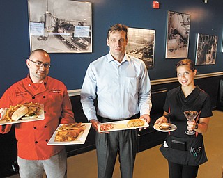 Head Chef John Forsythe, left, General Manager Jason Zishka and waitress Kayla Magni stand with entrees at Jack Perry’s Gastropub, which had its grand opening Wednesday at 5529 Mahoning Ave. in Austintown.
