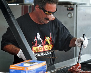 MADELYN P. HASTINGS | THE VINDICATOR

Dennis Wray of Fayetteville, Arkansas wears a pig nose while slathering barbecue sauce on a rack of ribs at the Eastwood Rib Fest in Niles on Saturday, July 20. The event runs through Sunday.