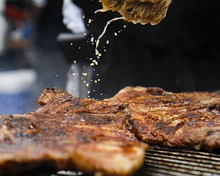 MADELYN P. HASTINGS | THE VINDICATOR

Willie Coleman marinates racks of ribs on the grill for the 'Hot Sauce Williams' booth at the Eastwood Rib Fest in Niles on Saturday, July 20. The event runs through Sunday.