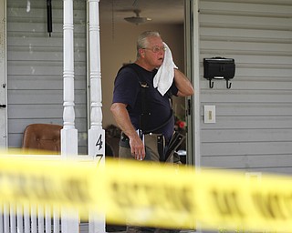 MADELYN P. HASTINGS | THE VINDICATOR

Campbell firefighter Eugene Skelley wipes off his face on the porch of 47 7th Street where a 5 victim shooting and fire occurred on Saturday, July 20.