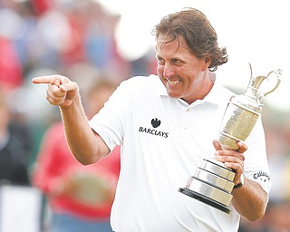 Phil Mickelson gestures as he holds the Claret Jug after winning the British Open at Muirfield in Gullane, Scotland, on Sunday. With four birdies over the last six holes, Mickelson captured his fifth major — and first British Open — with a 5-under 66 for a three-shot win over Henrik Stenson of Sweden.