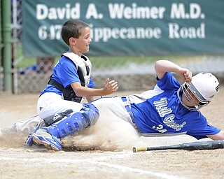 Mill Creek base runner #35 Nooch NeCato slides into home plate where he ail be tagged out by Poland catcher #4 Timmy Scotford in the bottom of the 4th inning.
