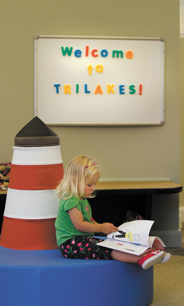 Gwen Gamble, 2, looks at a book at the Tri-Lakes branch of the Public Library of Youngstown and Mahoning County, 13820 Mahoning Ave., North Jackson. The new library has a lake theme with kayaks, books and lighthouse chairs. Gwen was there Monday with her mom, Jackie.