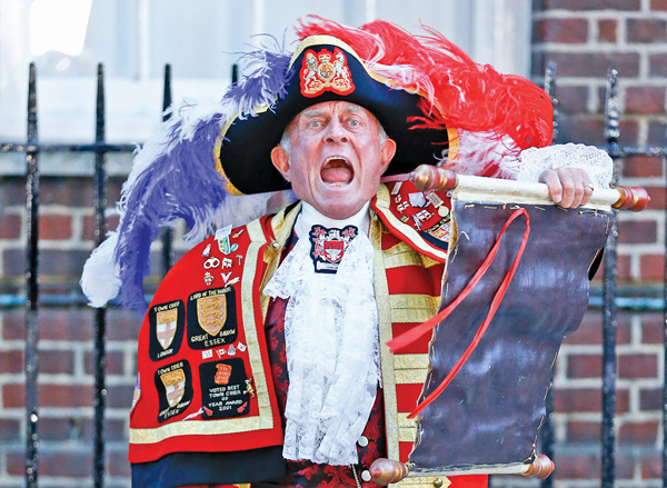 Tony Appleton, a town crier, announces the birth of the royal baby outside St. Mary’s Hospital in London on Monday. Palace officials say Prince William’s wife, Kate, gave birth to a baby boy at 4:24 p.m.