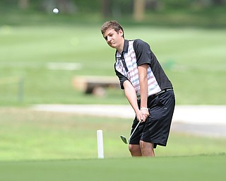 Charlie Loomis of Canfield chips his ball onto the green from the short rough on the 18th hole Wednesday afternoon at Mill Creek Golf Course. 