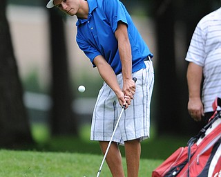 Gerry Booze chips his ball from the short rough and onto the green on a hole on the back 9 Sunday afternoon at Trumbull Country Club.