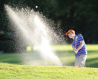 Tavish Burd chips his ball out of the sand trap and onto the green on the 18th hole Sunday afternoon at Trumbull Country Club.