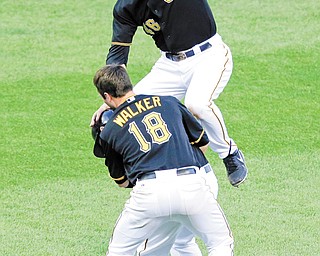 The Pirates’ Garrett Jones, top, and Neal Walker (18) tackle teammate Alex Presley, rear, after he drove in the game-winning run with a single off Cardinals relief pitcher Kevin Siegrist in the 11th inning of the first baseball
game of a doubleheader Tuesday. Pittsburgh won the opener, 2-1. The Pirates finished a sweep of St. Louis with a 6-0 victory in the second game.