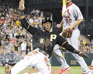 The Pirates’ Starling Marte (6) scores from third on a sacrifice fly by Andrew McCutchen in the fifth inning
Wednesday night. St. Louis starting pitcher Adam Wainwright (50) backs up the throw.