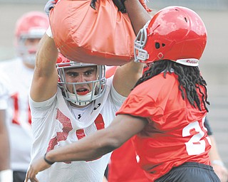 Youngstown State linebacker Dom Rich (20) hits a blocking bag being held by Ian Banks-Tillman (29) during the Penguins’ first preseason practice Thursday at Stambaugh Stadium.