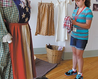 Alina Taylor, 13, of Boardman looks at Civil War-period costumes. This week, Alina is participating in the Mahoning Valley Historical Society’s Turning Points Civil War Summer Day Camp.