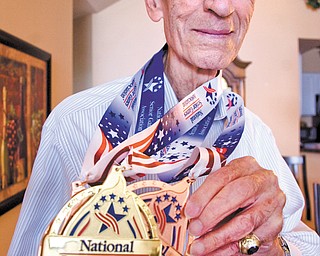 Bessemer, Pa., native Joe Tiratto, 87, wears the medals that he won while competing in the 2013 National
Senior Games, which took place July 19-Aug. 1 in Cleveland. Tiratto’s haul included a gold medal in singles
pickleball, a bronze in mixed-doubles pickleball and a bronze in singles bocce.