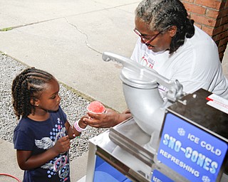 MADELYN P. HASTINGS | THE VINDICATOR..Anita Davis of Youngstown gives 5-year-old Fara Winlock of Youngstown a snowcone at the Youngstown National Night Out at Wick Park on August 6, 2013. This is part of National Night Out program, dedicated to the development and promotion of various crime-prevention programs including neighborhood watch groups, law enforcement agencies, state and regional crime prevention associations, businesses, civic groups, and individuals, devoted to safer communities.... - -30-..