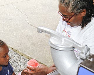 MADELYN P. HASTINGS | THE VINDICATOR..Anita Davis of Youngstown gives 5-year-old Fara Winlock of Youngstown a snowcone at the Youngstown National Night Out at Wick Park on August 6, 2013. This is part of National Night Out program, dedicated to the development and promotion of various crime-prevention programs including neighborhood watch groups, law enforcement agencies, state and regional crime prevention associations, businesses, civic groups, and individuals, devoted to safer communities.... - -30-..