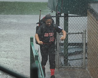 Canfield player #10 Sydney Fabry sprints for protection from the rain after grabbing her equipment from the dugout. 