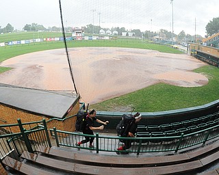 Canfield players #00 Ally Sammarco and #14 Jenna Gibson sprint for cover from a downpour that postponed their game Wednesday afternoon at Firestone Stadium in Akron. 