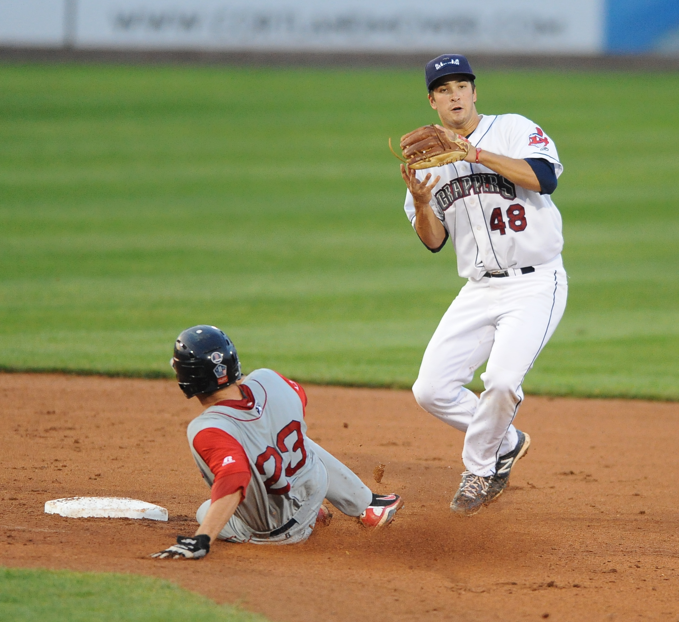 Scrappers infielder #48 James Roberts jumps in the air after stepping on second base after stepping on second base to force out Lowell base runner #23 Danny Bathea. The throw to first base would not be in time to first. 