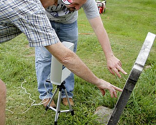 MADELYN P. HASTINGS | THE VINDICATOR
(L-R) Tom Delvaux and Matt O'Mansky look over the eroded tombstone of George Foulkes. O’Mansky is using a 3-D scanner to try to make out the words on the tombstone in the Glenview Cemetery in East Palestine. O'Mansky was contacted by Jerry Ward, who is a descendant of Foulkes. Foulkes was captured by Indians as a young boy in 1780 and remained a captive for 11 years before escaping.