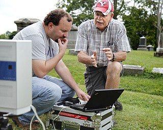 MADELYN P. HASTINGS | THE VINDICATOR
(L-R) Matt O'Mansky and Tom Delvaux look at the results of a 3-D scan of the eroded tombstone of George Foulkes. O’Mansky is using the scanner to try to make out the words on the tombstone in the Glenview Cemetery in East Palestine. O'Mansky was contacted by Jerry Ward, who is a descendant of Foulkes. Foulkes was captured by Indians as a young boy in 1780 and remained a captive for 11 years before escaping.