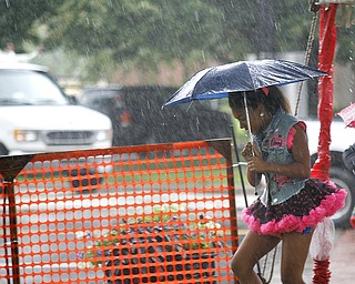 MADELYN P. HASTINGS | THE VINDICATOR
Camryn Stewart, 9, of Warren runs through the rain before her performance with Natalie's Dance Company at the Warren Italian Festival on Thursday, August 8. The festival runs through Sunday.