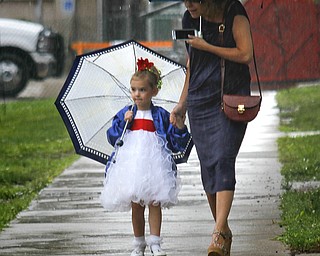 MADELYN P. HASTINGS | THE VINDICATOR
(L-R) Sadee Zamarelli, 4, and her aunt Maureen of Warren try to stay out of the rain that delayed the Warren Italian Festival on Thursday, August 8. Sadee participated in the Miss Italian Pageant. The festival runs through Sunday.