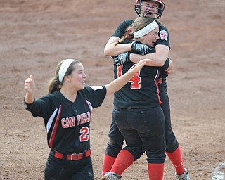 Canfield player #2 Maddy Johns gets a hug from teammate #14 Jenna Gibson after knocking in the game wining hit while #21 Ellie Dundics walks around the infield in disbelief.