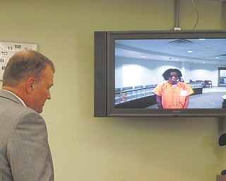 Atty. Mark Hanni stands before a video monitor in Warren Municipal Court on Thursday with his client, Lakeisha Bell,19, of Williamsburg Street Northwest in Warren. Bell is charged in last weekend’s death of her friend, McKayla Hopkins, 18, at Bell’s birthday party in Perkins Park.