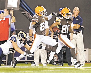 The Browns’ Travis Benjamin (80), escorted by teammate Trevin Wade (26), eludes the Rams’ Mike McNeill and returns a punt 91 yards for a touchdown in the second quarter of a preseason NFL game Thursday in Cleveland. The Browns won 27--19.